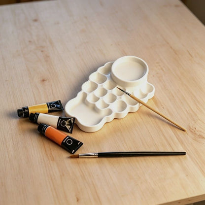 Built-in water bowl on a plastic watercolor palette for rinsing brushes and diluting paint